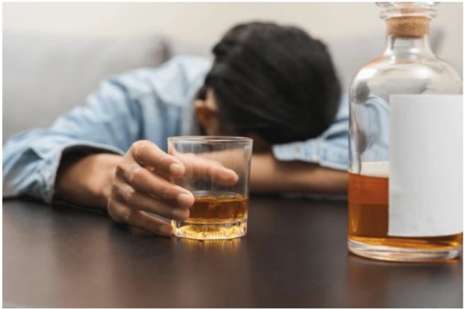 Person with alcohol bottle and glass