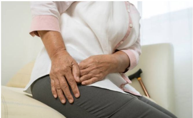 Person holding their hip in pain